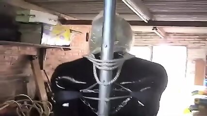 PatsyPVC Shiny Tight PVC Skirt Sissy Tranny Slut In Rope And Chain Bondage With Large Ballgagged And Anal Buttplug With Shiny Black Seamed Stockings And High Heels Stored In Garage